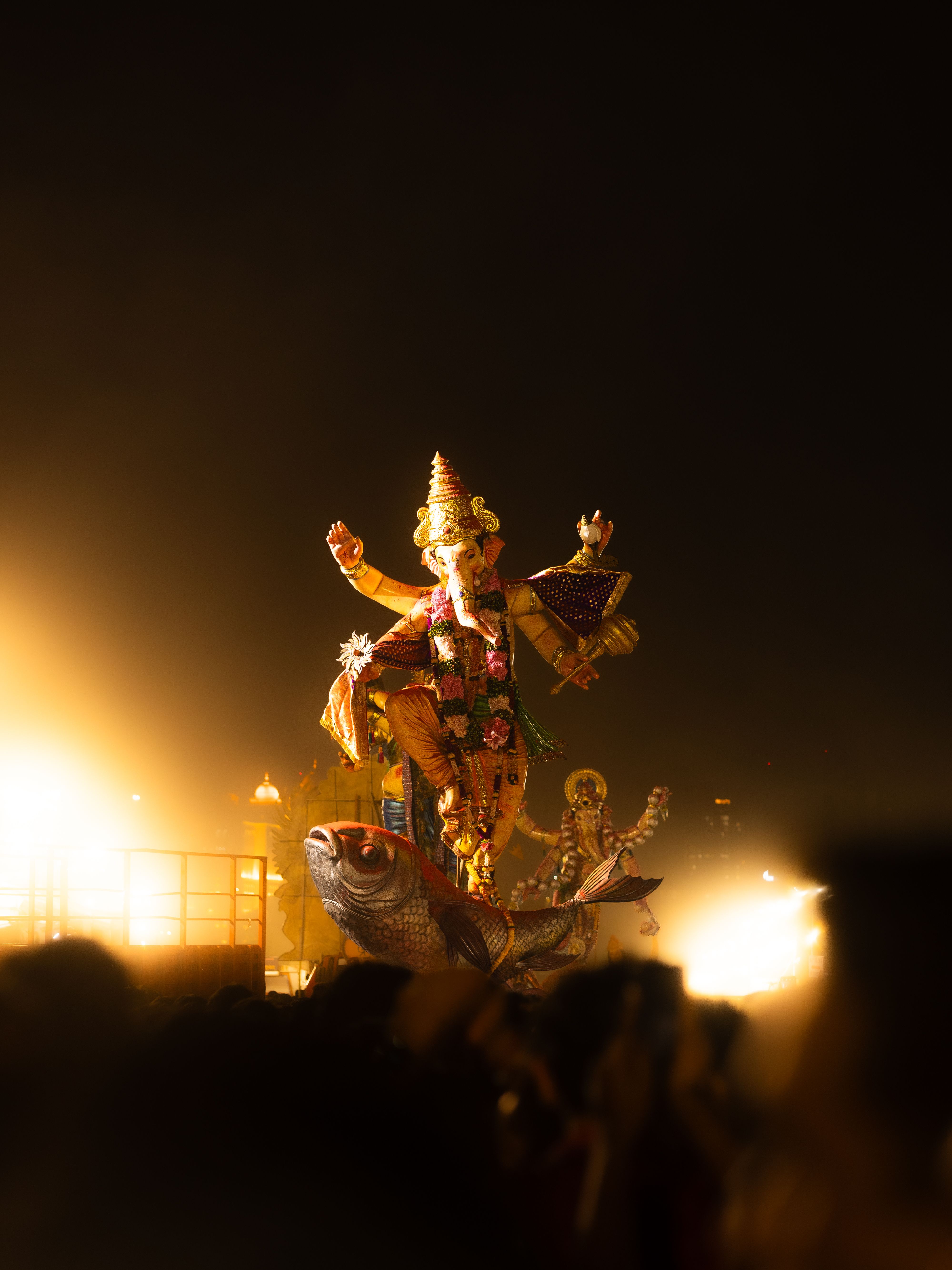 A vibrant Ganesh idol illuminated during a night festival in Mumbai, India, showcasing cultural richness.