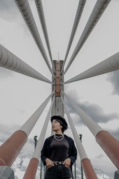 女子在现代时尚风格下，于引人注目的建筑结构前摆姿势