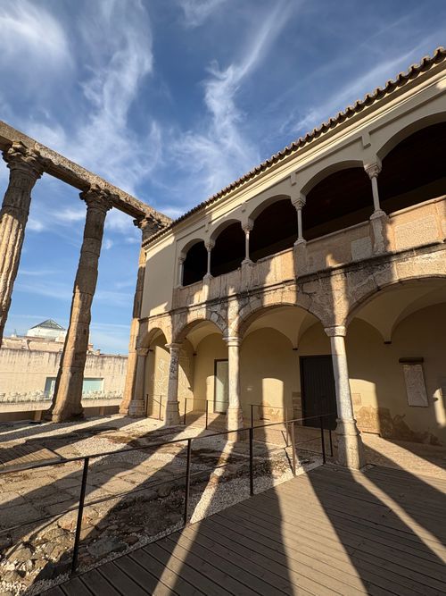 Free View of ancient Roman temple ruins with arches and columns in Merida, Spain under a blue sky. Stock Photo