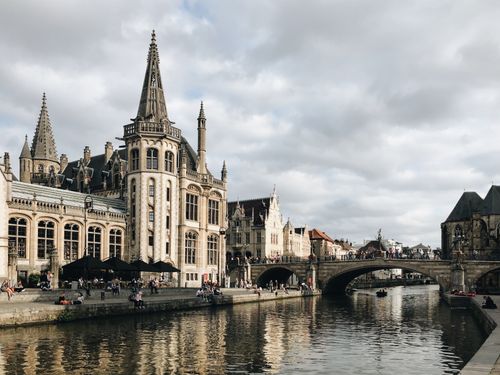 Free Captivating view of Ghent's stunning architecture along the canal with a bustling urban scene. Stock Photo