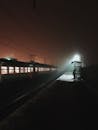 Silhouette Of Person Standing On Train Platform At Night Time