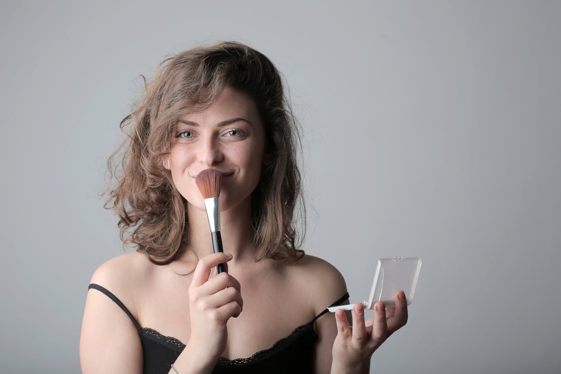 Woman in Black Spaghetti Strap Top Holding a Make up Brush