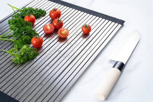 Cherry tomatoes and parsley with a knife on a wet cutting board, showcasing freshness and kitchen prep.