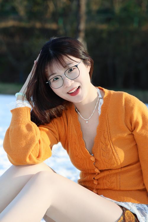 Free Cheerful young woman with glasses enjoys a sunny outdoor day in Hefei. Stock Photo