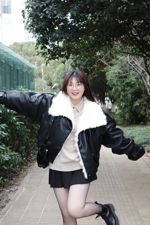 Free Happy young woman with arms outstretched on a nature path in Hefei, China, wearing winter attire. Stock Photo