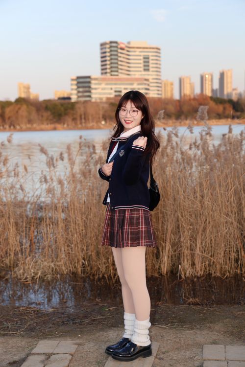 Free Portrait of a young woman in school uniform by a lakeside in Hefei, China during daytime. Stock Photo