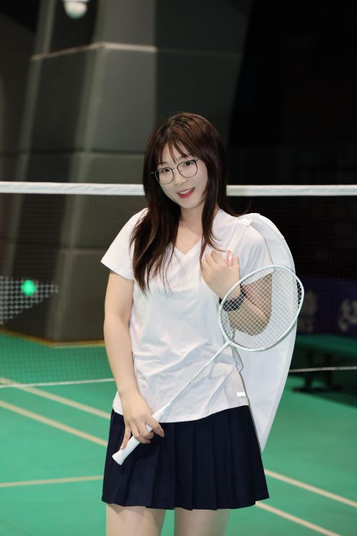 Free Cheerful young woman with badminton racket on indoor court in Hefei, China. Stock Photo
