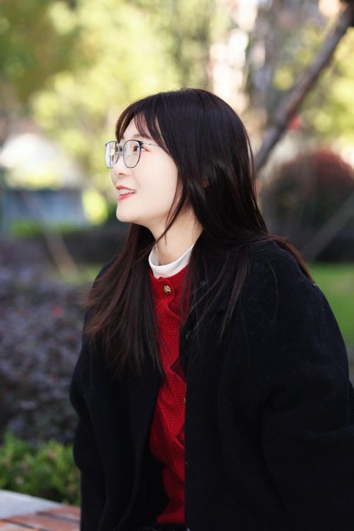 Free East Asian woman in glasses smiling while outdoors in Hefei park. Stock Photo