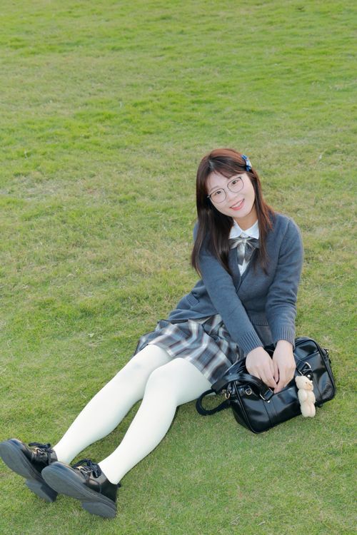 Free Cheerful woman in school uniform enjoying a sunny day outdoors in Hefei, China. Stock Photo