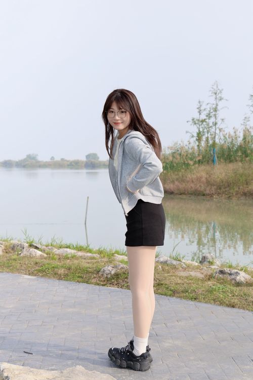 Free A young woman poses near a serene lake in Hefei, Anhui, China during a clear day. Stock Photo
