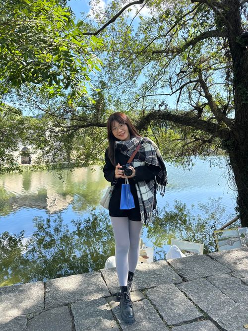 Free Woman with camera by a lake in Hefei, Anhui, captured in the vibrant fall season. Stock Photo