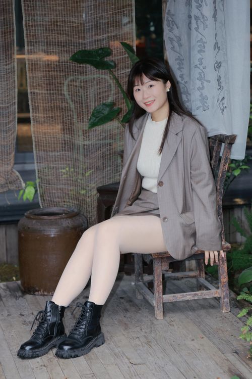 Free Asian woman in stylish outfit sitting outdoors in Hefei, Anhui, capturing a natural moment. Stock Photo