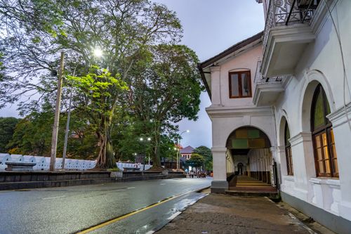 Free A quiet rainy morning street scene in Kandy, Sri Lanka, highlighting colonial architecture and lush trees. Stock Photo