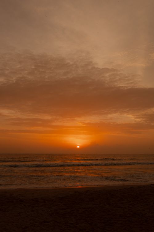 Free A breathtaking sunset over the ocean with warm tones and gentle waves, creating a tranquil atmosphere. Stock Photo