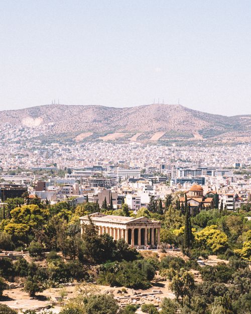 Free A scenic view of the Temple of Hephaestus in Athens, Greece, with a backdrop of the city and mountains. Stock Photo