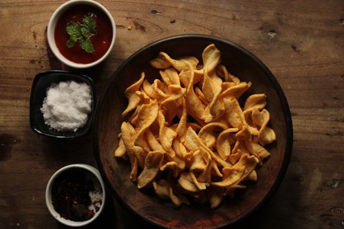 Free A bowl of snack chips with sauces and spices on a rustic wooden table. Stock Photo