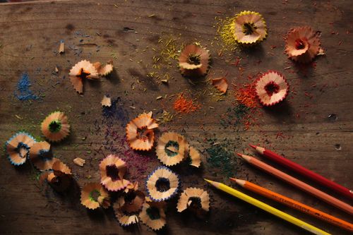 Free A vibrant display of pencil shavings and colored pencils on a wooden table. Stock Photo