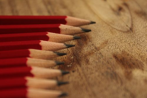 Free Close-up of aligned red pencils on a wooden texture, perfect for artistic and educational themes. Stock Photo