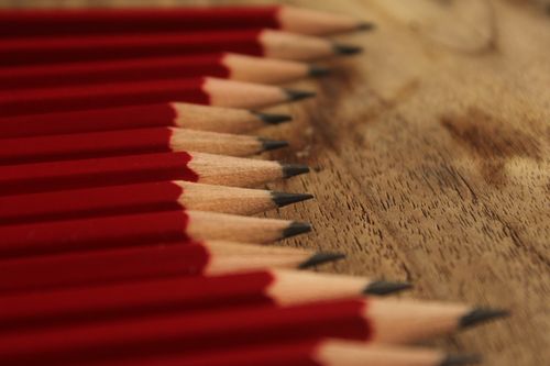 Free Neatly sharpened red pencils perfectly aligned on a wooden surface, showcasing symmetry and precision. Stock Photo