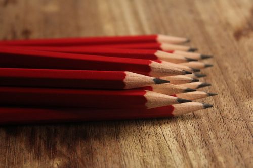 Free A collection of red pencils neatly arranged on a wooden surface, showcasing sharp tips. Stock Photo