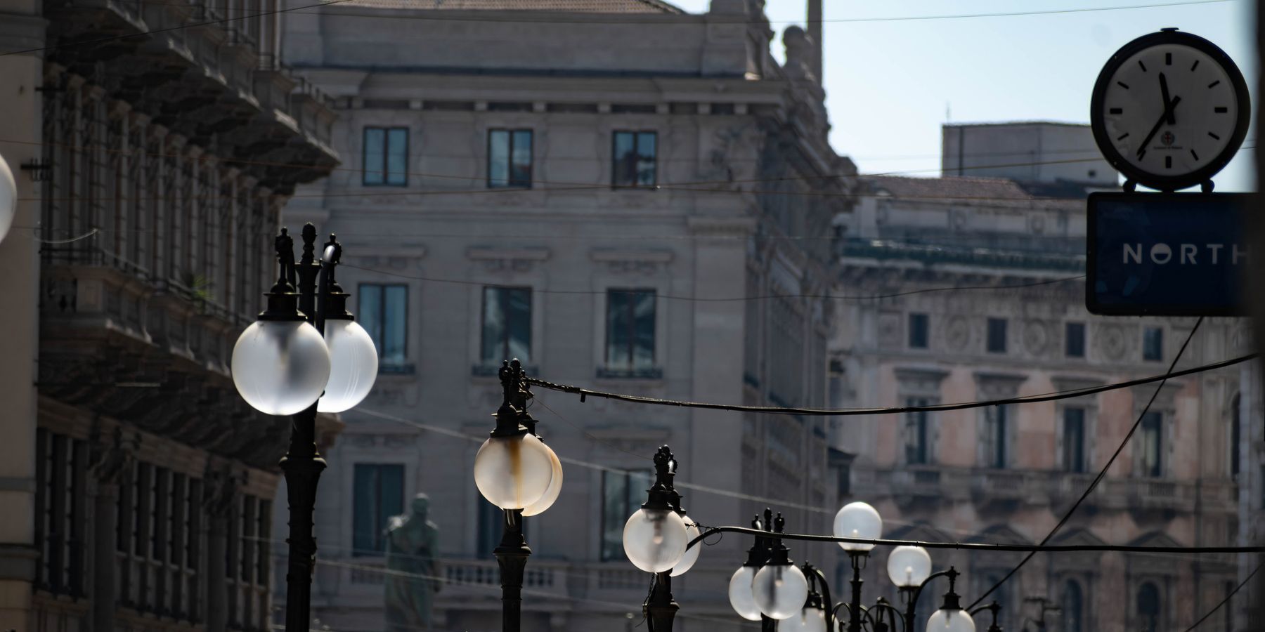 Historic architecture in Milan with decorative lamp posts lining elegant streets.