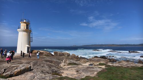 Free A scenic view of a lighthouse overlooking the rocky coastline and ocean waves. Stock Photo