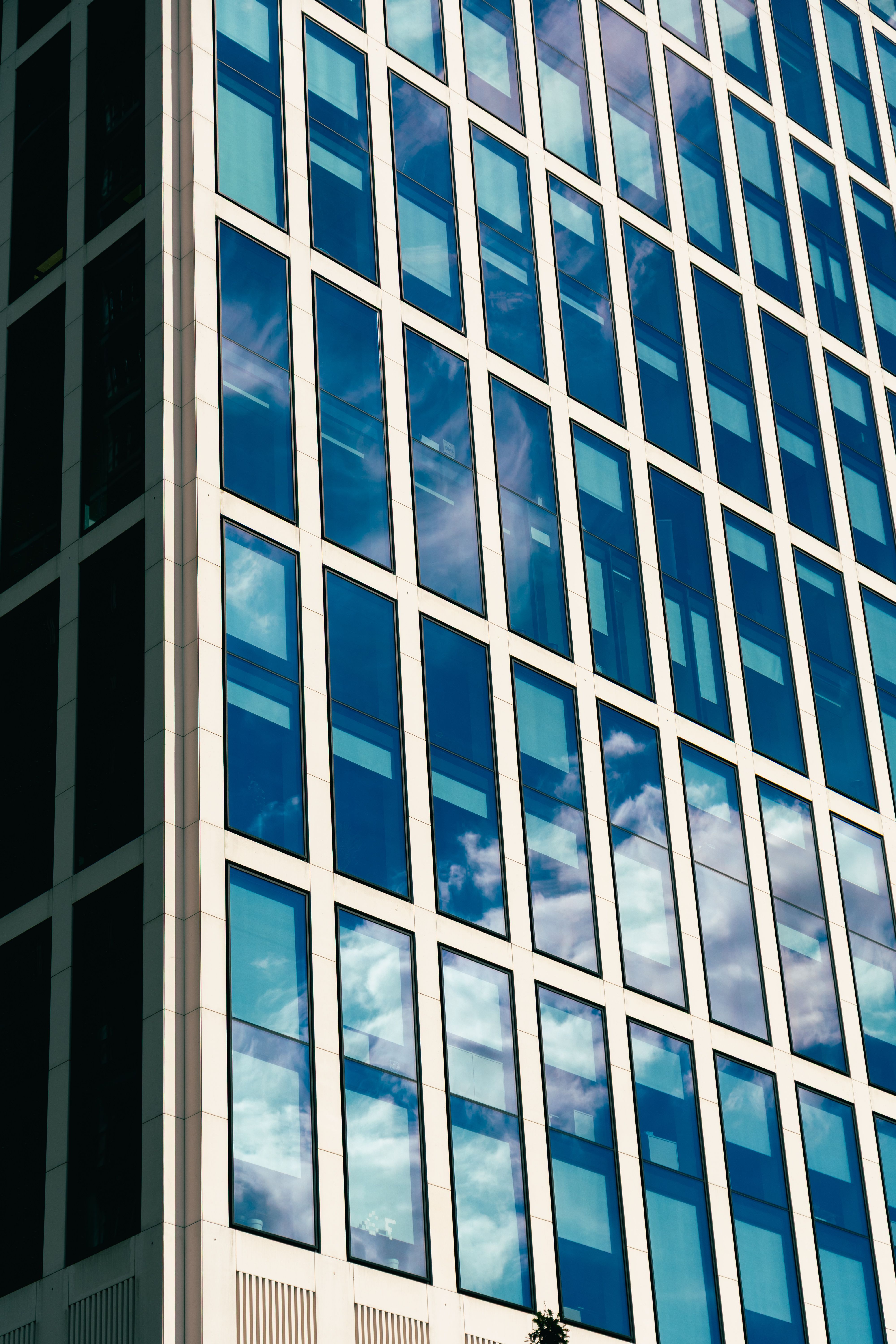 Fotomural Vista desde arriba de la fachada de vidrio reflectante de un rascacielos en Frankfurt, que muestra los reflejos de las nubes.
