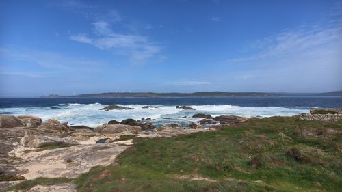 Free A peaceful coastal scene with rocky shoreline, ocean waves, and distant horizon. Stock Photo