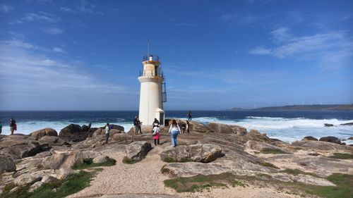 Free A scenic view of tourists visiting a coastal lighthouse in northwest Spain. Stock Photo