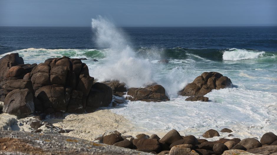 Fotomural Las poderosas olas del océano chocan contra la costa rocosa, creando un paisaje marino espectacular.