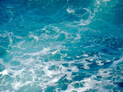 Free Dynamic capture of bright turquoise ocean waves with frothy white surf. Stock Photo