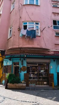 A vibrant pink and blue corner shop in Istanbul with laundry hanging above, reflecting local culture.
