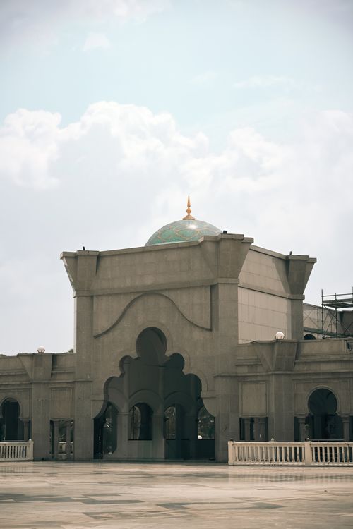 Free Elegant architectural details of a mosque in Kuala Lumpur, showcasing Islamic design elements against a blue sky. Stock Photo