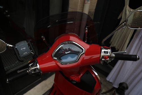 Free Detailed view of a red scooter handlebar and dashboard showing speedometer and controls. Stock Photo