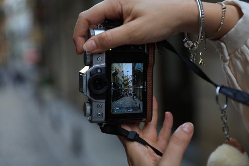 Free Photographer captures a charming street scene with a digital camera outdoors. Stock Photo