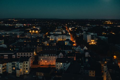Free Dramatic aerial view of a city at night with illuminated streets and buildings. Stock Photo