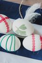 From above of Easter eggs decorated with red and green ribbons and put on table covered with soft fabric