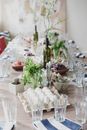 Creative table setting for celebration of Easter with green tree branches in vine bottles