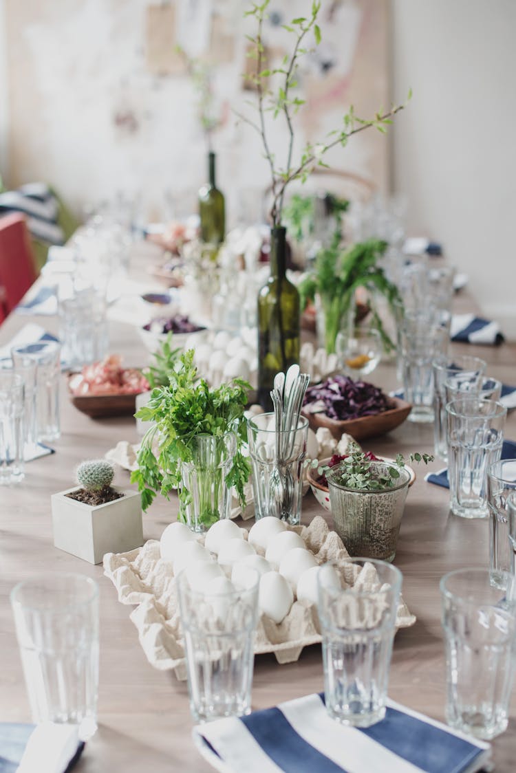 Creative Table Setting For Celebration Of Easter With Green Tree Branches In Vine Bottles