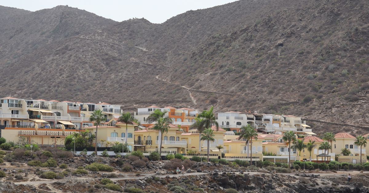 Scenic view of coastal villas nestled against mountain backdrop in Tenerife, Spain.