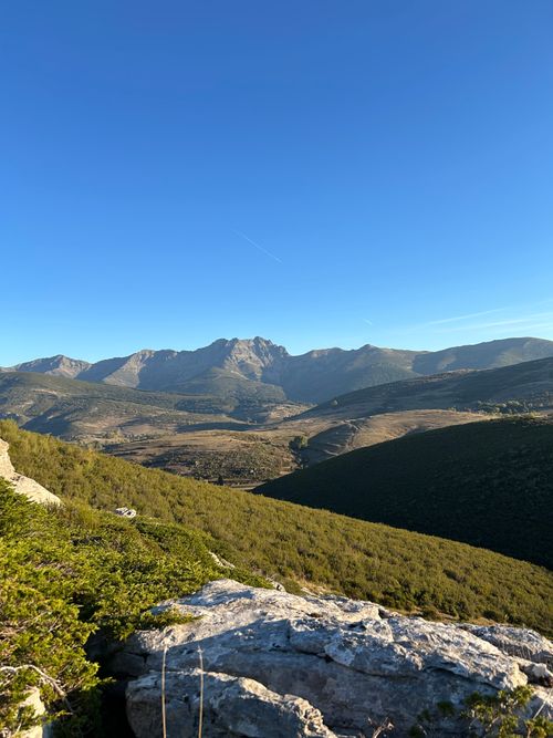 Free Scenic view of mountains under a clear blue sky in Spain, showcasing lush greenery and rugged terrain. Stock Photo