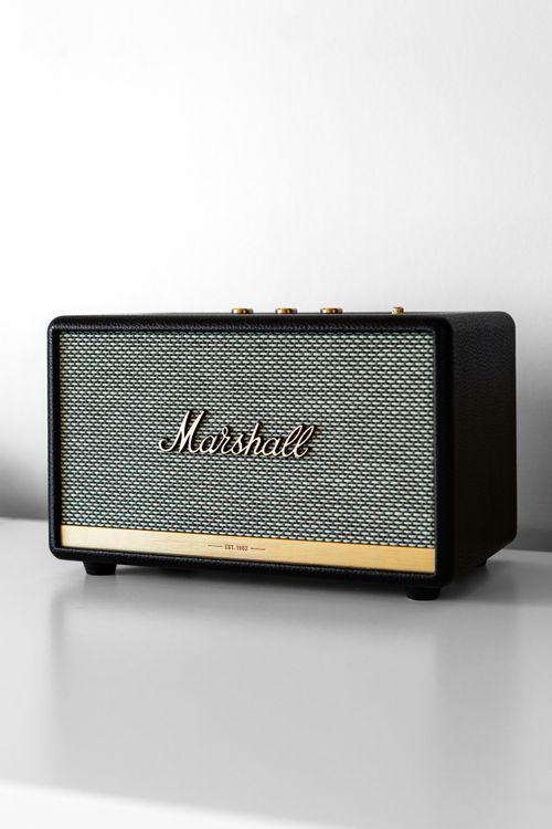 Free A sleek Marshall Bluetooth speaker on a white minimalist shelf, highlighting modern audio design. Stock Photo