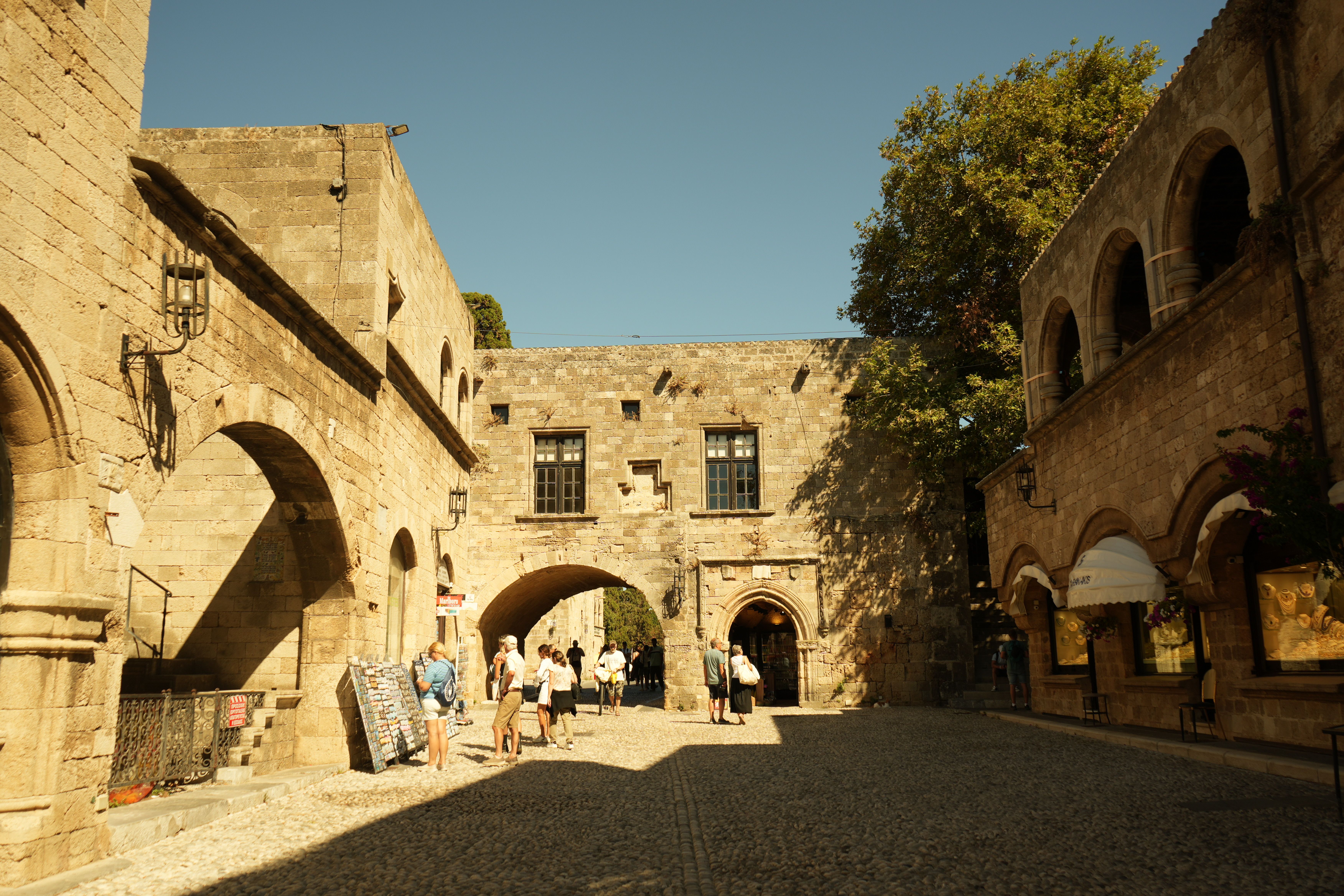 A warm summer day in Rhodes Old Town showing medieval stone buildings.