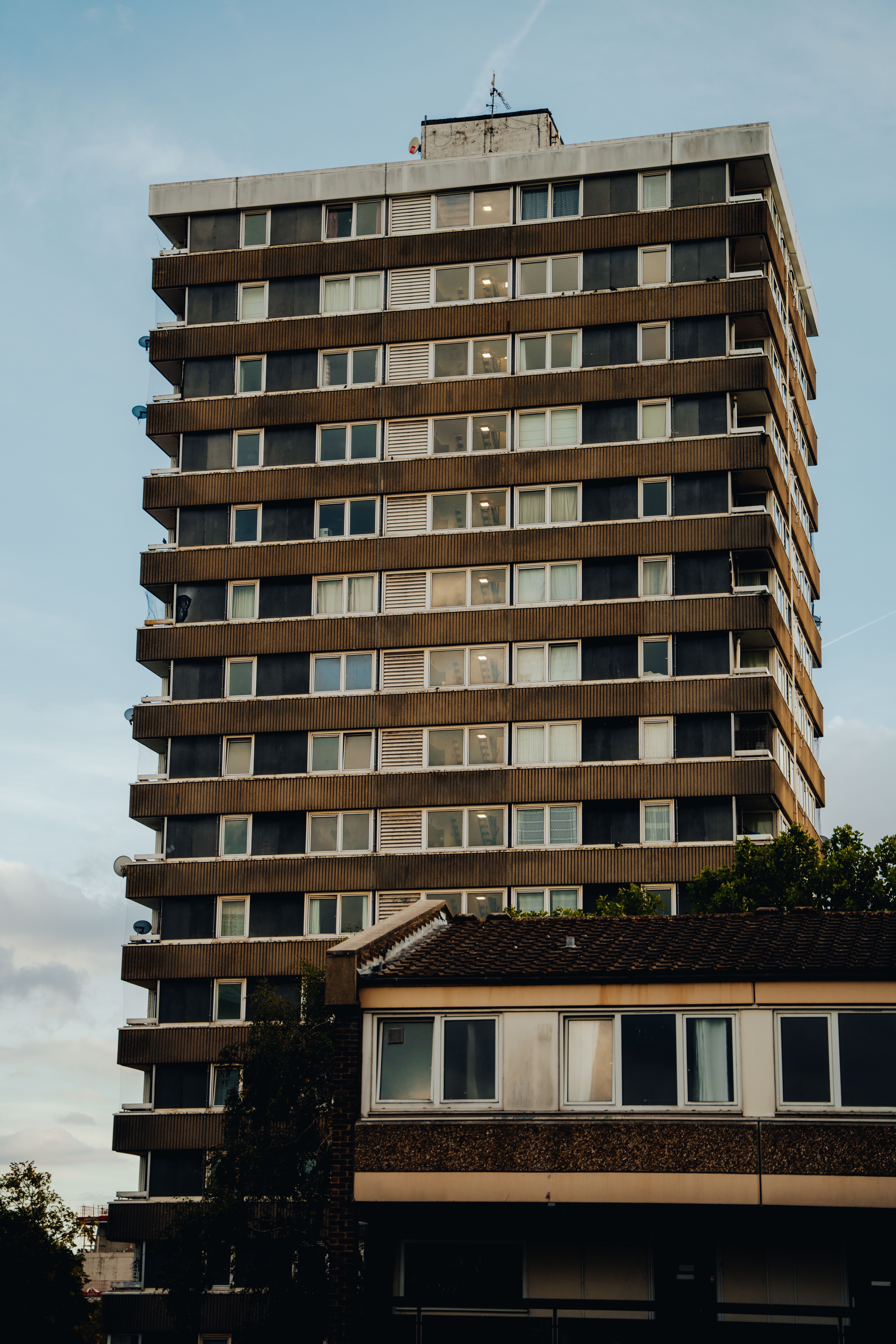 Modern residential tower in Kingston upon Thames, England, with clear blue sky.