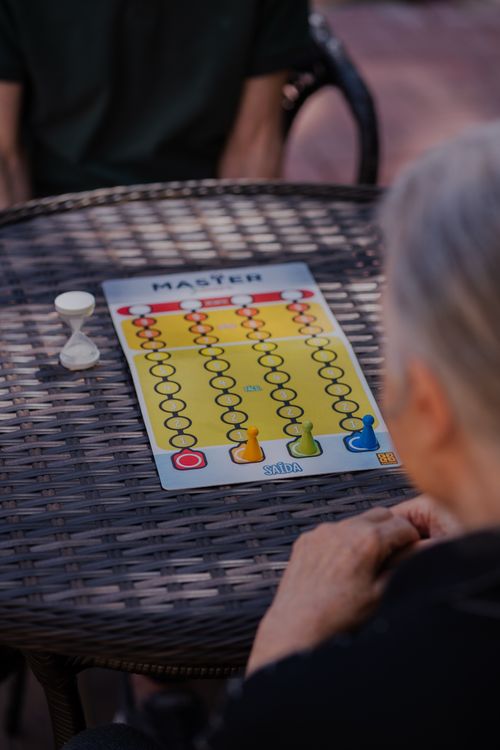 Free Two senior adults engaged in a strategy board game at an outdoor setting, promoting leisure and interaction. Stock Photo