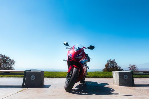 Free A red sports motorcycle parked on a scenic outdoor vista under a clear blue sky. Stock Photo