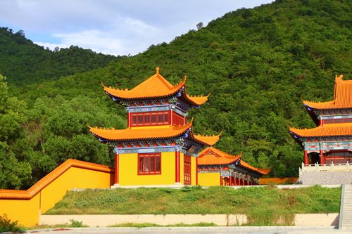Free Vibrant Chinese temple nestled in lush green mountains, symbolizing serenity and tradition. Stock Photo