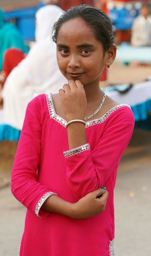 Free Young girl poses confidently outdoors in a vibrant pink dress, showcasing cultural fashion. Stock Photo