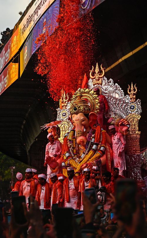 Free Devotees celebrate Ganesh Chaturthi with vibrant colors and joyous festivities under an overpass. Stock Photo