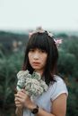 优雅女子头戴花冠，手捧花束，散发着自然的美感